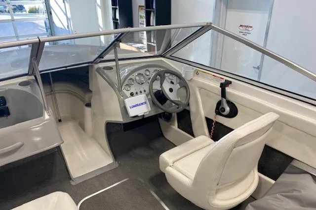 Slide: The Image of 2012 Bayliner 195 Discovery boat interior with steering wheel and dashboard controls. - 13