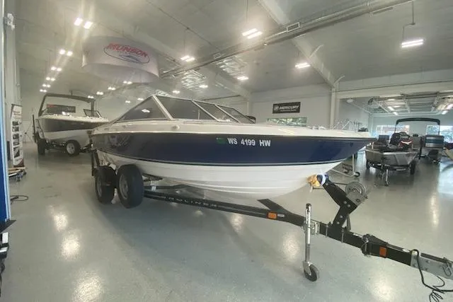 Slide: The Image of 2012 Bayliner 195 Discovery boat on trailer in showroom setting. - 2