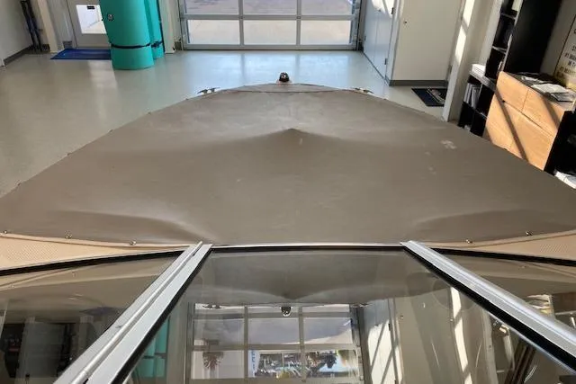 Slide: The Image of 2012 Bayliner 195 Discovery boat with covered bow in a garage setting. - 9