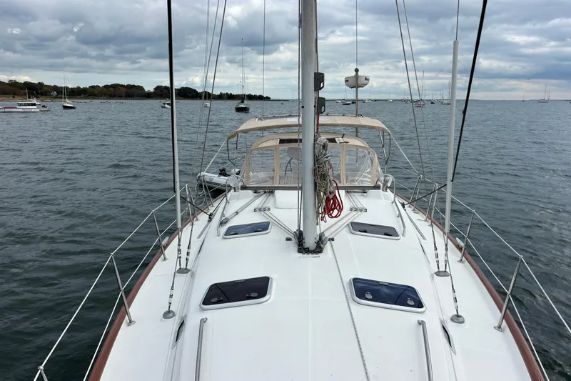 Slide: The Image of 2002 Beneteau Oceanis 411 sailboat on calm waters under cloudy skies. - 13