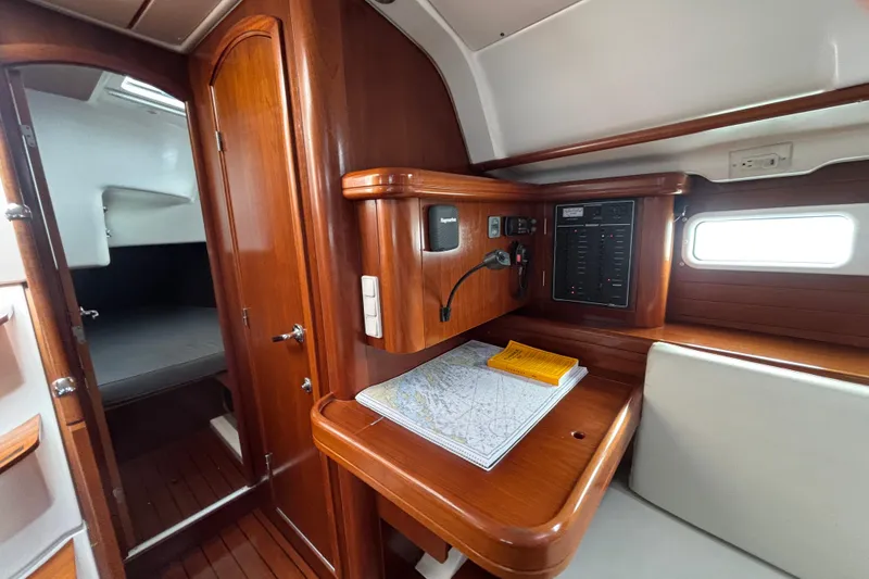 Slide: The Image of Interior of 2002 Beneteau Oceanis 411 sailboat with navigation station and wooden cabinetry. - 20