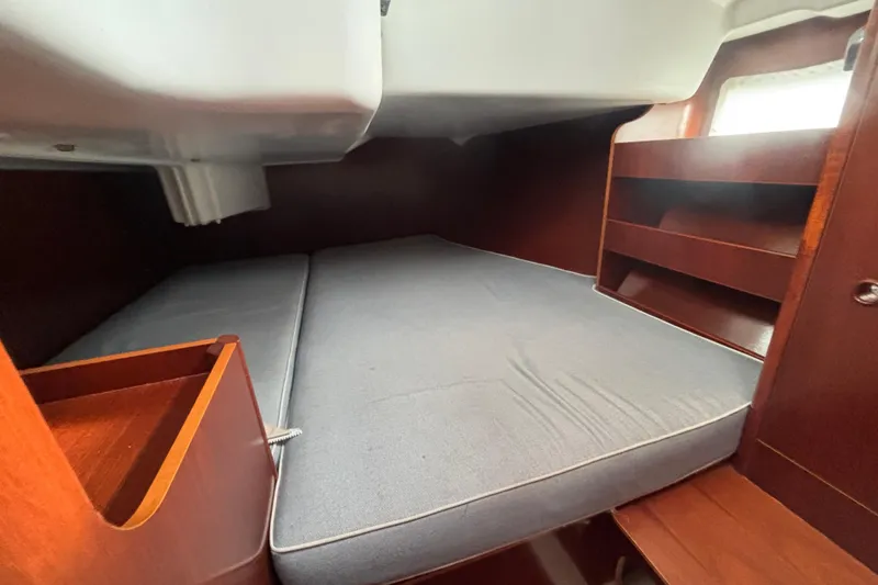 Slide: The Image of Interior cabin of 2002 Beneteau Oceanis 411 sailboat with wooden shelves and bed. - 22