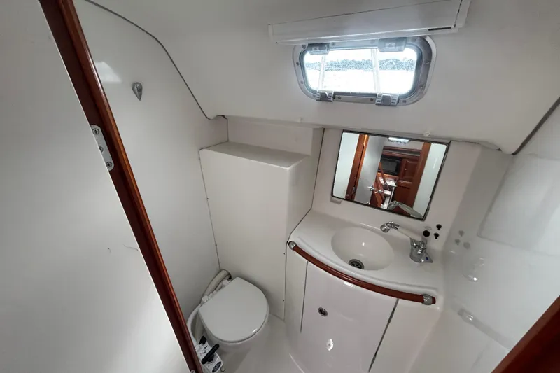 Slide: The Image of Bathroom interior of 2002 Beneteau Oceanis 411 yacht with sink, toilet, and mirror. - 23
