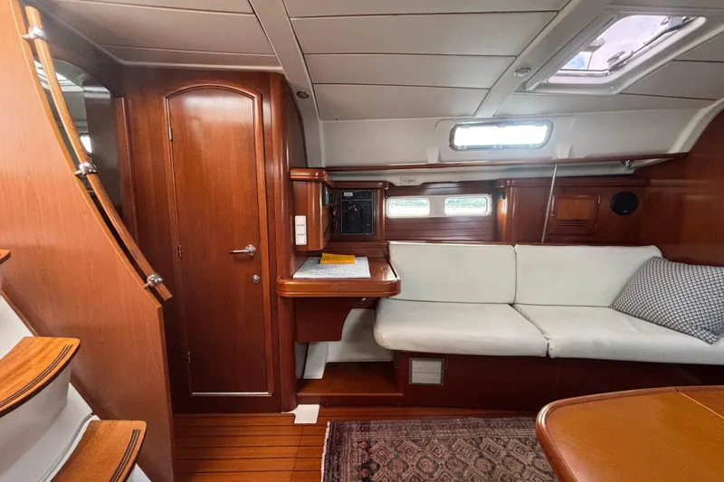 Slide: The Image of Interior of 2002 Beneteau Oceanis 411 yacht with wooden finish and white seating. - 31