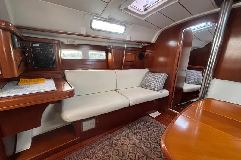 Slide: The Image of Interior of 2002 Beneteau Oceanis 411 sailboat with wooden finish and white seating. - 32