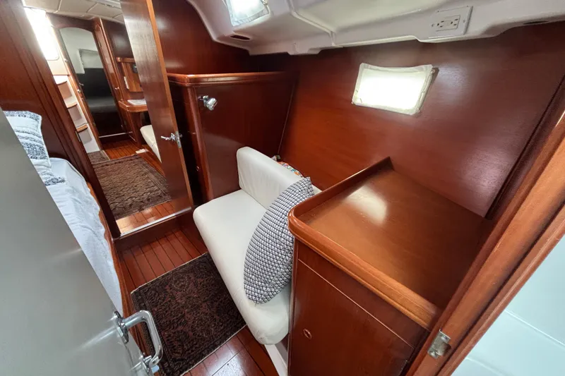 Slide: The Image of Interior of 2002 Beneteau Oceanis 411 yacht, featuring wood paneling and cozy seating area. - 37