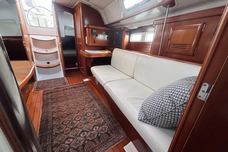 Slide: The Image of Interior of 2002 Beneteau Oceanis 411 yacht with wooden flooring and white seating. - 38