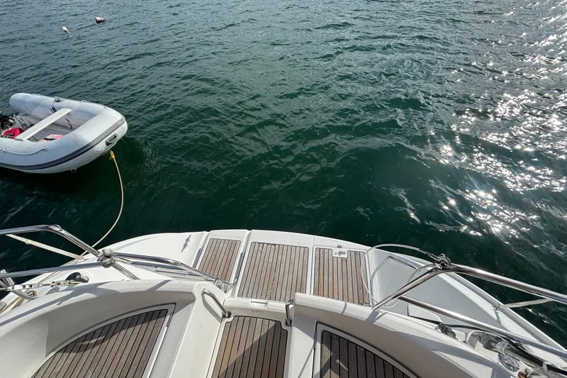 Slide: The Image of Beneteau Oceanis 411 yacht deck with inflatable dinghy on water, 2002 model. - 42