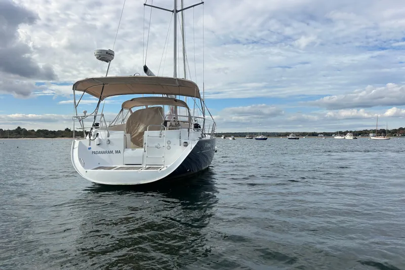 Slide: The Image of 2002 Beneteau Oceanis 411 sailboat on calm water under cloudy sky. - 44