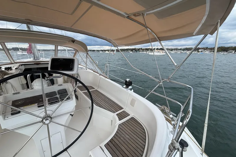 Slide: The Image of 2002 Beneteau Oceanis 411 sailboat cockpit with steering wheel, overlooking marina. - 9