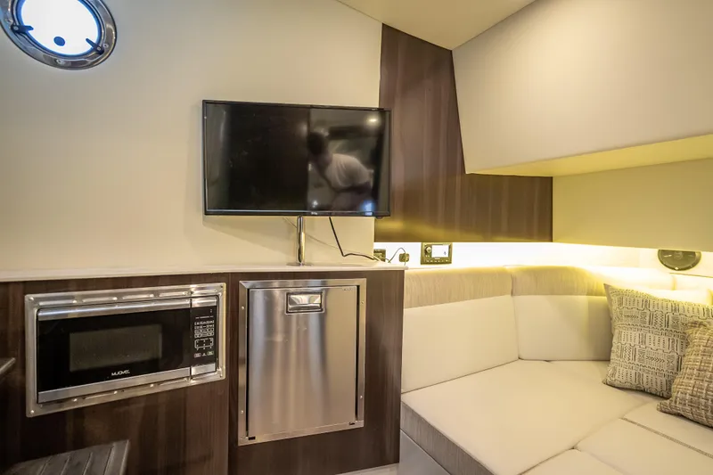 Slide: The Image of 2022 Cruisers Yachts 38 GLS OB interior with TV, microwave, and cozy seating area. - 27