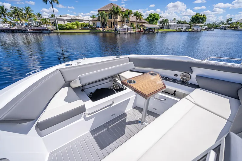 Slide: The Image of 2022 Cruisers Yachts 38 GLS OB boat interior with seating and table on a sunny day. - 14