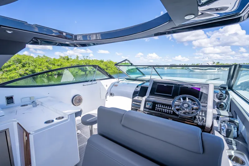 Slide: The Image of 2022 Cruisers Yachts 38 GLS OB cockpit with modern controls and scenic water view. - 19