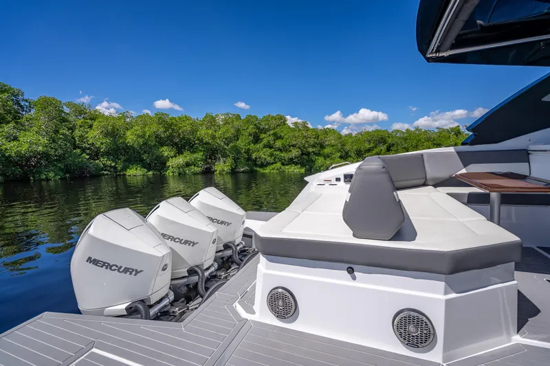 Slide: The Image of 2022 Cruisers Yachts 38 GLS OB with Mercury engines, docked by lush greenery. - 37