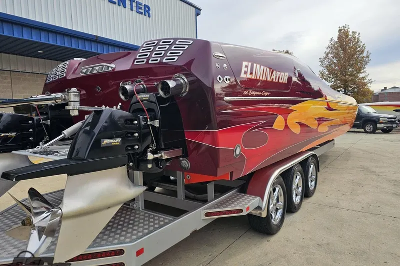 Slide: The Image of 2008 Eliminator 36 Daytona Coupe speedboat with vibrant flame design on trailer. - 14