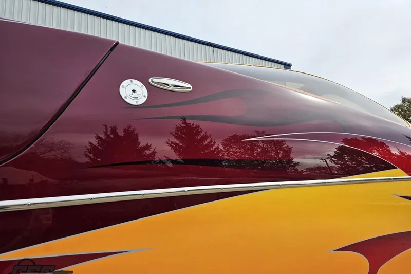 Slide: The Image of 2008 Eliminator 36 Daytona Coupe with vibrant red and yellow flame design. - 16