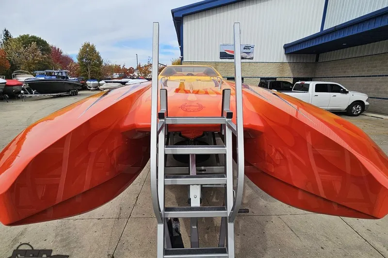 Slide: The Image of 2008 Eliminator 36 Daytona Coupe in vibrant orange, parked outdoors with a ladder. - 24
