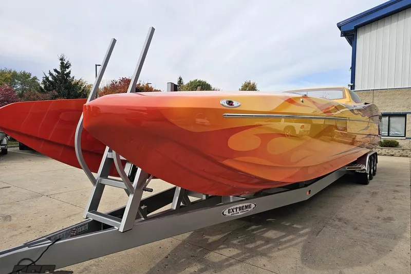 Slide: The Image of 2008 Eliminator 36 Daytona Coupe boat with vibrant orange flame design on trailer. - 28