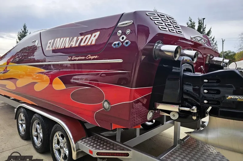 Slide: The Image of 2008 Eliminator 36 Daytona Coupe boat with vibrant flame graphics on a trailer. - 36