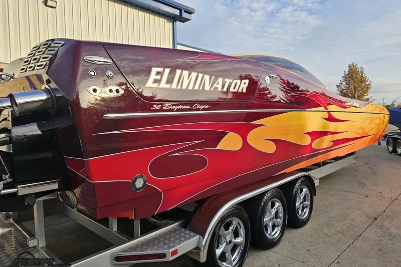 Slide: The Image of 2008 Eliminator 36 Daytona Coupe speedboat with vibrant flame design on trailer. - 42
