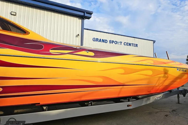 Slide: The Image of 2008 Eliminator 36 Daytona Coupe with vibrant flame design at Grand Sport Center. - 5
