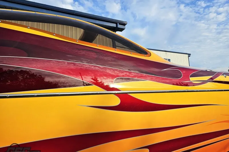 Slide: The Image of 2008 Eliminator 36 Daytona Coupe with vibrant red and yellow flame design. - 6