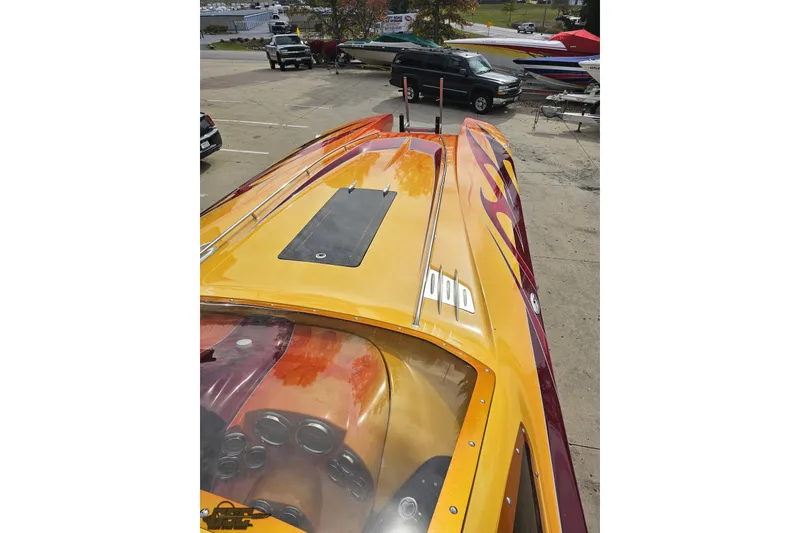 Slide: The Image of 2008 Eliminator 36 Daytona Coupe with vibrant flame design, parked outdoors. - 64