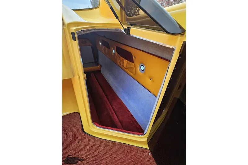 Slide: The Image of 2008 Eliminator 36 Daytona Coupe interior with yellow and red accents, open storage compartment. - 72