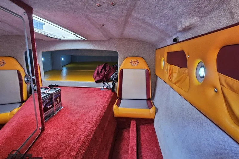 Slide: The Image of Interior of 2008 Eliminator 36 Daytona Coupe with red and yellow seating, carpet, and storage. - 74