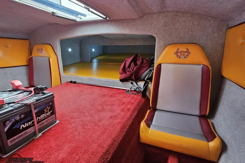 Slide: The Image of Interior of 2008 Eliminator 36 Daytona Coupe with red and yellow seating, battery, and storage area. - 75