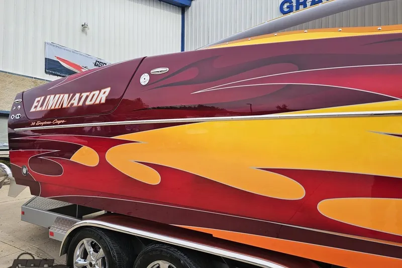 Slide: The Image of 2008 Eliminator 36 Daytona Coupe with vibrant red and yellow flame design on trailer. - 9