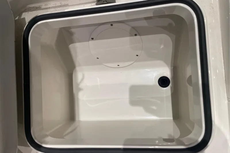Slide: The Image of Livewell compartment in 2026 Ranger 2510 Bay boat, featuring a drain and white interior. - 16