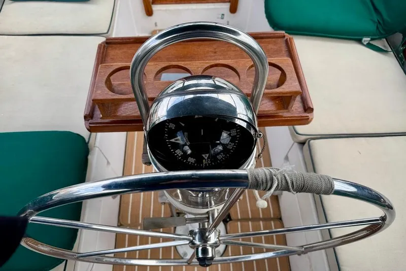 Slide: The Image of Steering wheel and compass of 1981 Bristol 45.5 Aft Cockpit sailboat, with wooden tray. - 12