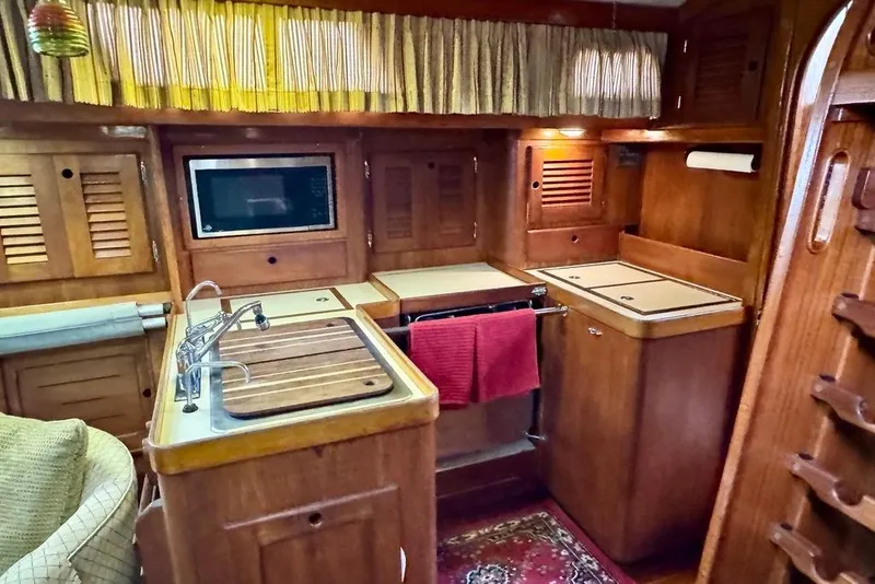 Slide: The Image of 1981 Bristol 45.5 Aft Cockpit yacht kitchen with wood cabinetry and modern appliances. - 26
