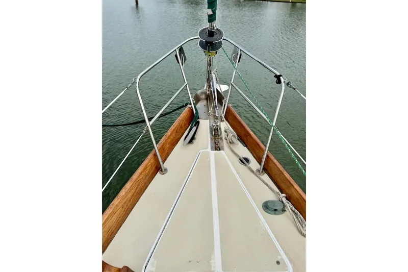 Slide: The Image of 1981 Bristol 45.5 Aft Cockpit sailboat deck with wooden railings and water view. - 5