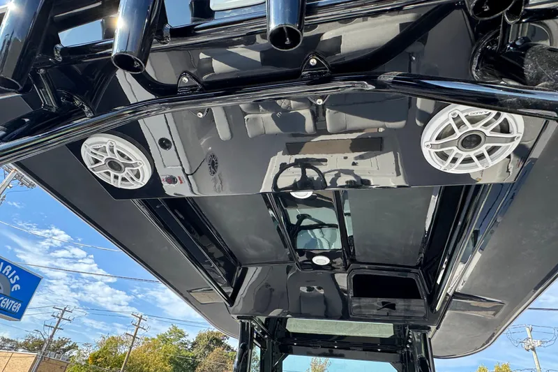 Slide: The Image of 2026 Stingray 253 CC boat roof with speakers and rod holders under clear sky. - 11