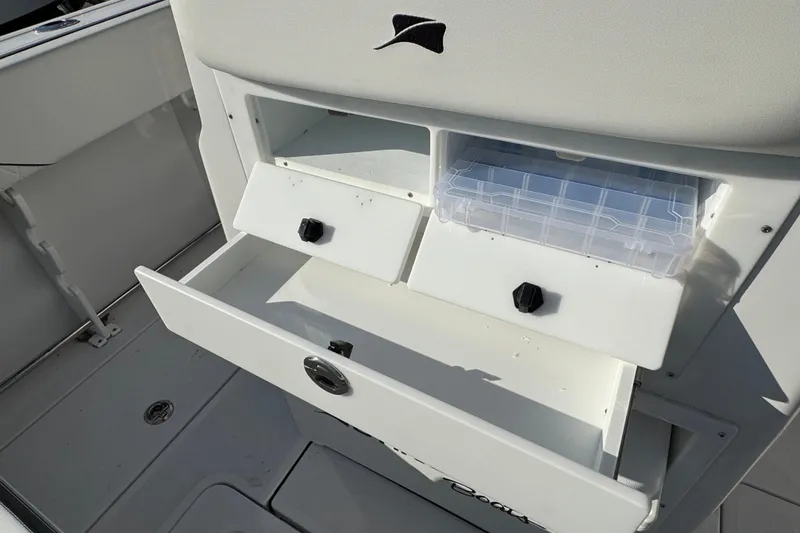 Slide: The Image of 2026 Stingray 253 CC boat storage compartments with tackle box and drawers. - 8