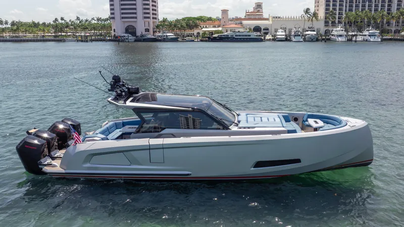 Slide: The Image of 2023 Vanquish Yachts VQ45 luxury boat on calm water near a marina. - 23