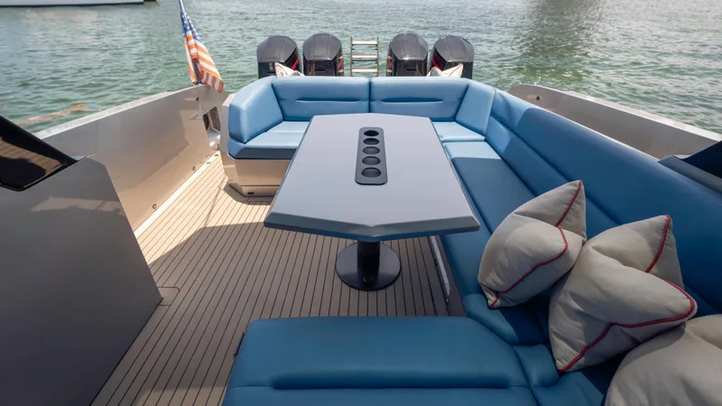 Slide: The Image of Luxurious 2023 Vanquish Yachts VQ45 deck with blue seating and table, overlooking water. - 43