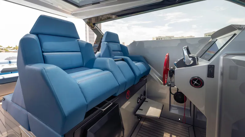 Slide: The Image of 2023 Vanquish Yachts VQ45 interior with blue seating and modern helm controls. - 44