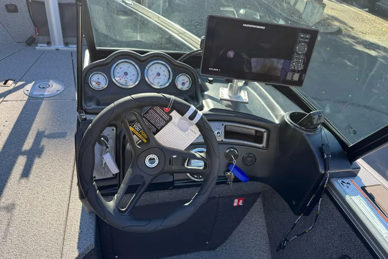 Slide: The Image of 2026 Lund 2075 Fisherman boat dashboard with steering wheel and navigation system. - 11