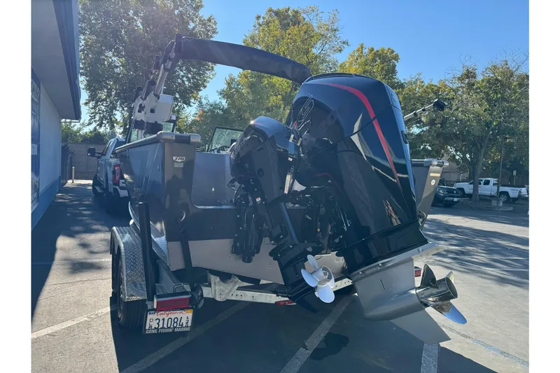 Slide: The Image of 2026 Lund 2075 Fisherman boat on trailer, parked outdoors, with powerful outboard motor. - 26