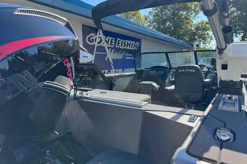 Slide: The Image of 2026 Lund 2075 Fisherman boat interior with Mercury engine, displayed at dealership. - 4