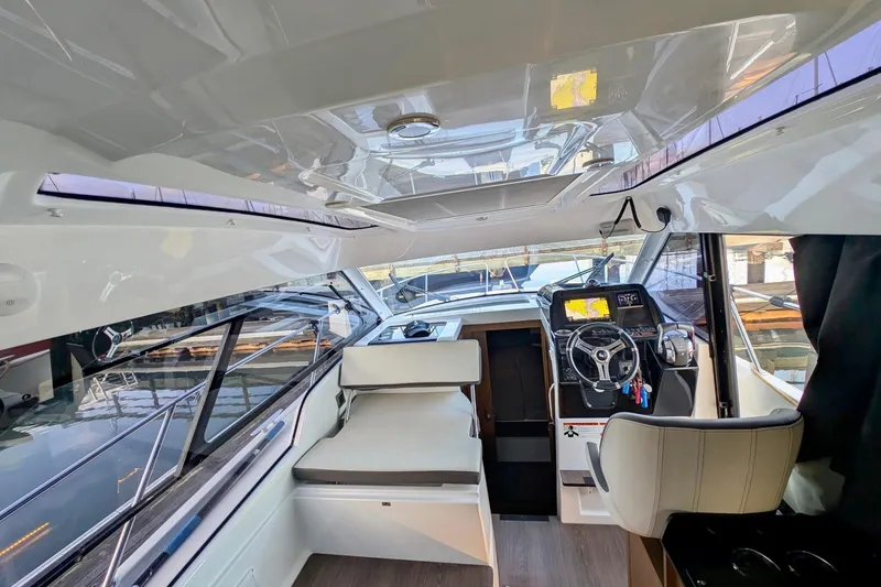 Slide: The Image of Interior of 2021 Beneteau Antares 9 boat, featuring modern helm and seating area. - 20