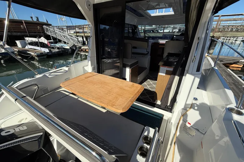 Slide: The Image of 2021 Beneteau Antares 9 boat interior with wooden table, docked at marina. - 22