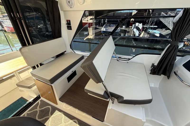Slide: The Image of Interior of 2021 Beneteau Antares 9 boat with seating and window view of marina. - 5