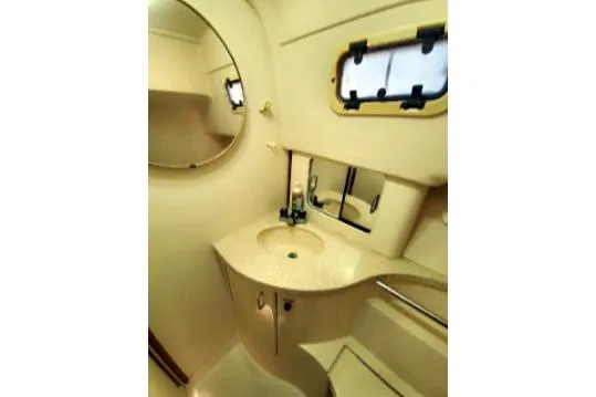 Slide: The Image of 1999 Mainship Pilot 30 boat bathroom with sink, mirror, and porthole window. - 18