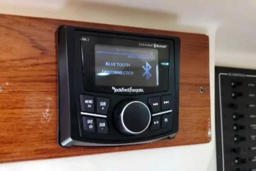 Slide: The Image of 1999 Mainship Pilot 30 boat stereo system with Bluetooth connectivity displayed on wooden panel. - 21