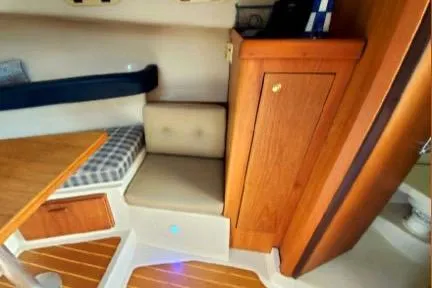 Slide: The Image of 1999 Mainship Pilot 30 cabin interior with wood accents and seating area. - 25