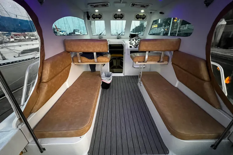 Slide: The Image of Interior of 1999 Mainship Pilot 30 boat with brown seating and modern dashboard. - 6